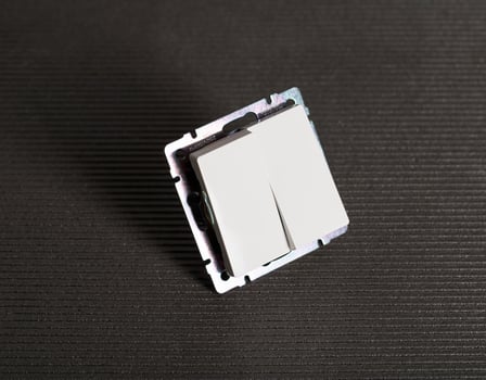 Modern two-gang switch on a gray background, close-up. Electric photo