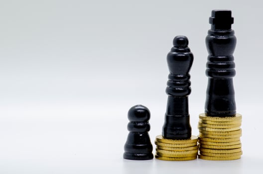 Status and Ambition Represented by black Pawns on Golden Coins. photo