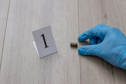 The gloved hand raises the cartridge from the cartridge, the investigation, the evidence, a close-up photo