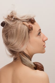 Beautiful young woman with snails on her face. Rejuvenation procedures photo