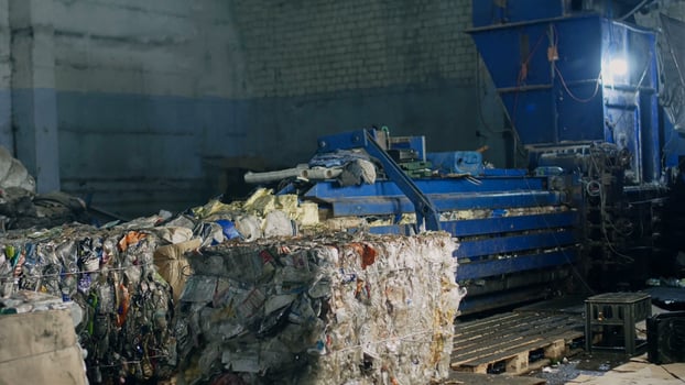 Press at waste recycling plant for pressing plastic and cardboard waste, processing photo