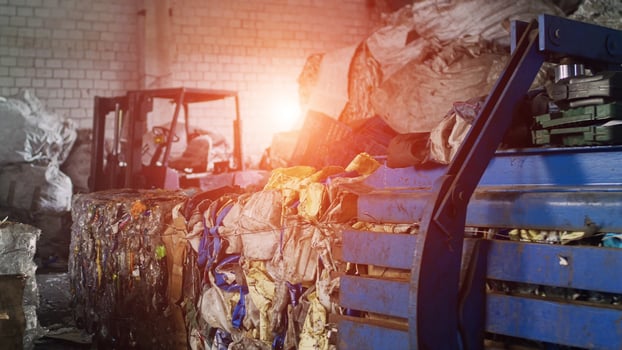 Large bales of pressed trash out of paper and plastic bottles at a recycling plant, industry, inside, sun photo