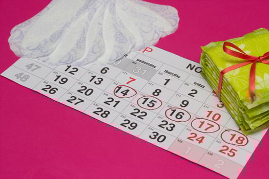Women's calendar on which are hygienic and daily pads, pink background, copy space, intimate photo