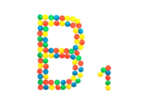 Multi-colored vitamins pills that are lined with the letter Vitamin group B1, cloes-up photo