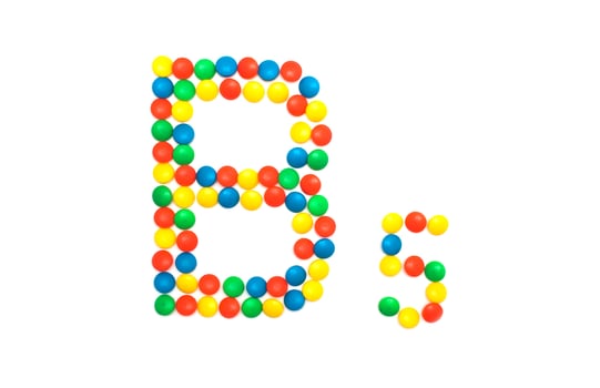 Multi-colored vitamins pills that are lined with the letter Vitamin group B5, close-up photo
