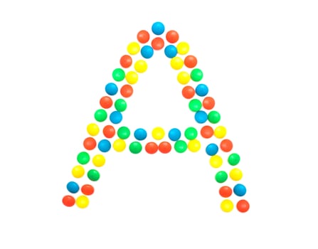 Multi-colored vitamins pills that are lined with the letter Vitamin group A, close-up photo