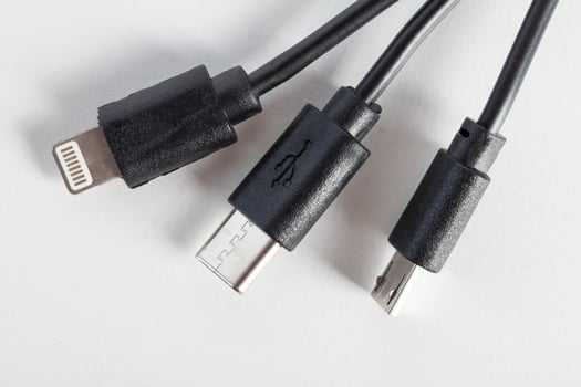 Universal black 3 in 1 charging cable with different charging connectors on a white background, close-up. Type-c, usb-c, micro-usb photo