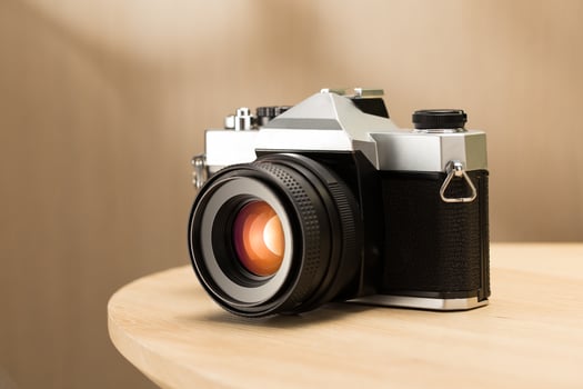 A vintage film camera sits elegantly on a table, showcasing timeless craftsmanship. photo