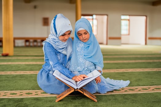 Two Muslim girls reading a Quran inside the mosque. photo