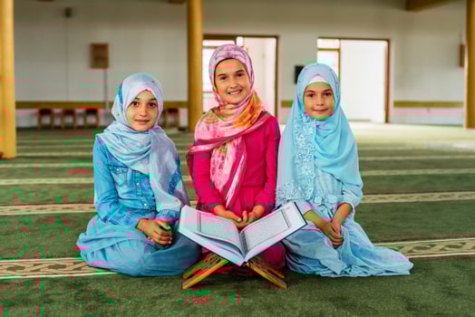 Group of a Muslim children reading a Quran inside the mosque. photo