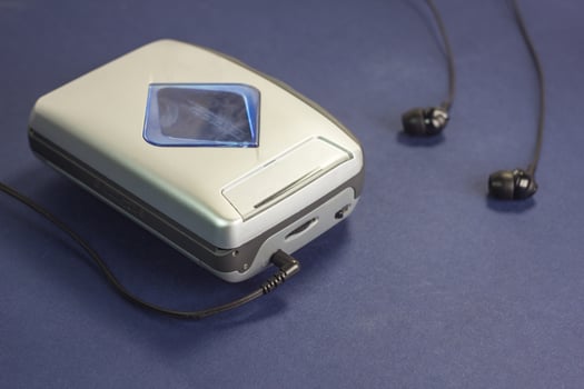 Cassette audio player and headphones on a blue background photo