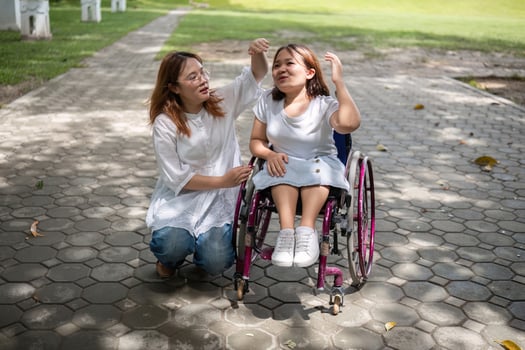 Young Woman in Wheelchair Enjoying a Walk in the Park with Her Best Friend on a Sunny Day photo