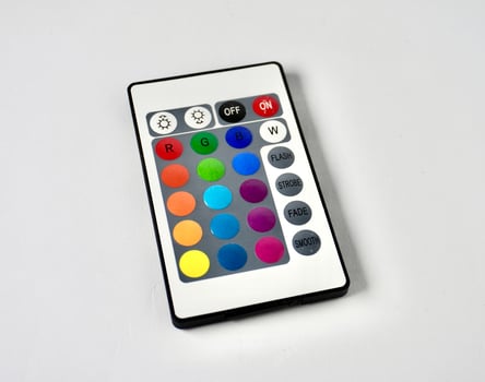 RGB lamp wireless remote control with colorful buttons isolated on horizontal ratio white background. photo
