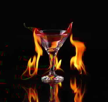 A martini glass with a chili pepper in the flame photo