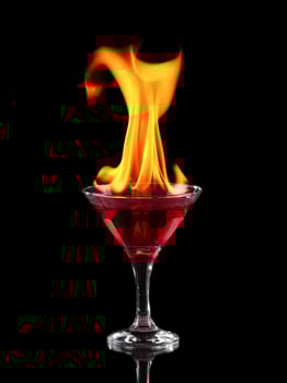 A red liquid in a martini glass with flames coming out of it photo