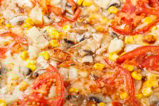 delicious pizza with chicken, mushrooms, cheese, tomatoes and corn on a wooden background photo