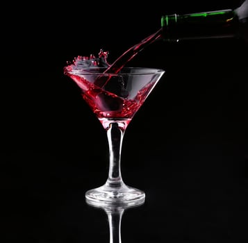red splashing cocktail on black photo