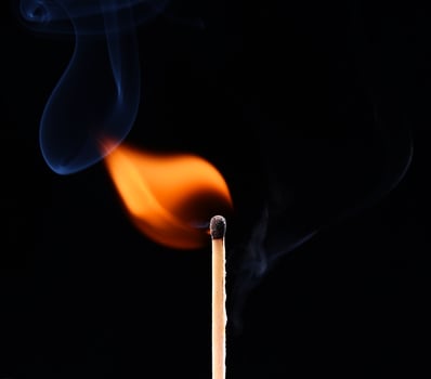 A matchstick with a flame and smoke photo