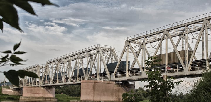 The freight train is moving along the railway bridge across the river photo