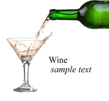 White wine pouring from the bottle intro the glass on white background photo