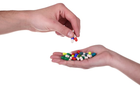 A person holding a handful of pills in their hand photo