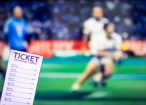 Bookmaker ticket on the background of the TV on which there is a sports game of cricket, sports betting, gambler photo
