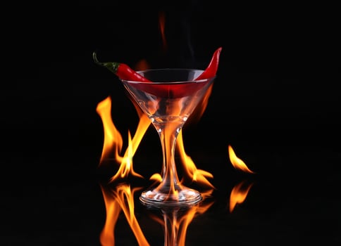 A martini glass with a red pepper in it photo