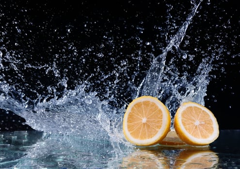 Sliced lemon in the water on black background photo