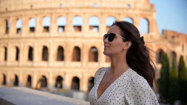 Confident woman in sunglasses enjoying the view of the Colosseum in Rome, Italy photo