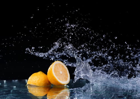 Sliced lemon in the water on black background photo