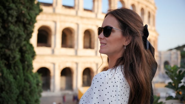 Stylish woman in polka-dot dress admiring the Colosseum in Rome, Italy photo
