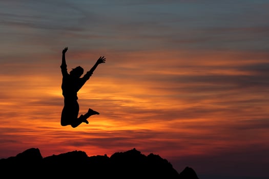 Happy woman jumping against beautiful sunset. Freedom, enjoyment concept. photo