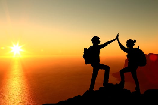The Silhouette of two man with success gesture standing on the top of mountain photo