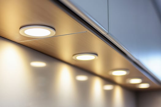 Recessed lighting installed above kitchen cabinets creates a sleek and stylish atmosphere photo
