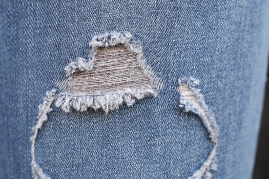 Featuring Stylish Ripped Jeans with Detailed Frayed Edges for a Trendy Look in Fashion photo