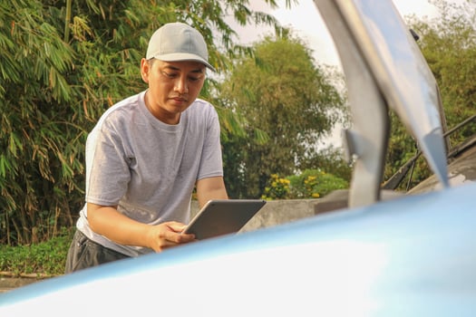 Asian men maintenance checking car service via insurance system at garage with using tablet photo