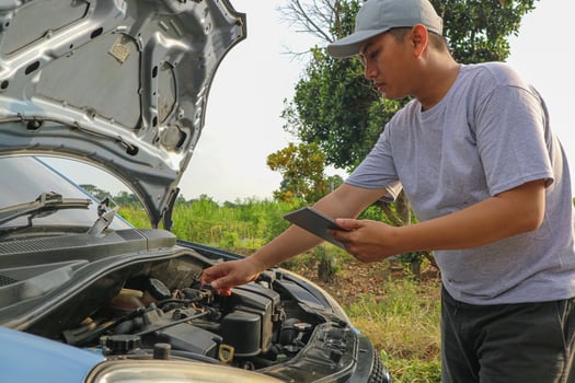 Auto check up and car service shop concept. Mechanic writing job checklist to clipboard to estimate repair quotation to client at workshop garage. photo