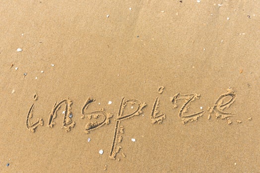 Inspire written on the beach sand photo