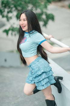 A woman wearing a blue shirt and black boots photo