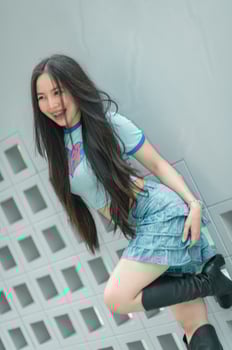 A woman in a blue shirt and skirt posing for a photo