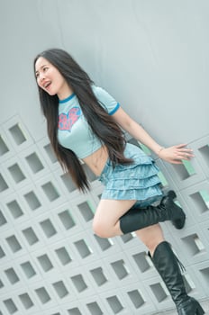 A woman wearing a blue shirt and black boots photo