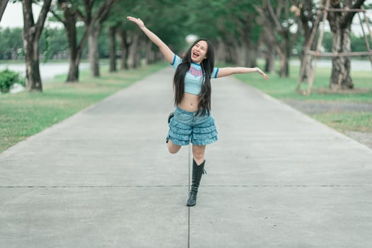 A woman in a blue shirt and shorts is jumping photo