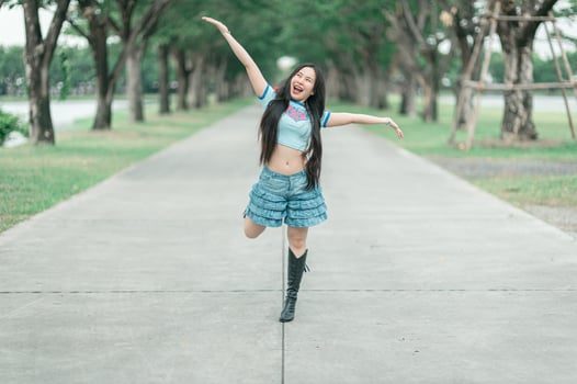 A woman in a blue skirt and boots is dancing photo