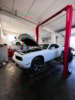Kyiv, Ukraine - November 22, 2024 Modern auto repair shop with Dodge Challenger car on hydraulic lift photo