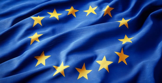 A blue and yellow flag with a star pattern. The flag is from Europe. The flag is waving in the wind photo