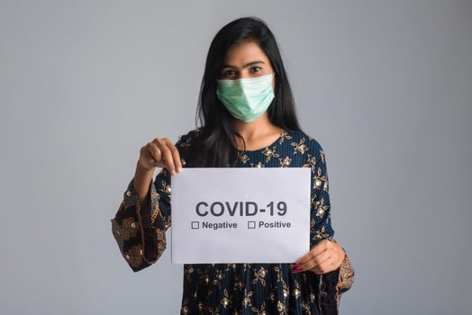 A young woman in a medical mask holding a board of the epidemic of Coronavirus, Covid-19 photo
