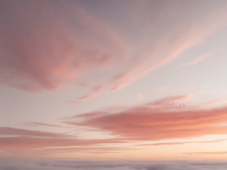A pink sky with clouds above the ocean photo