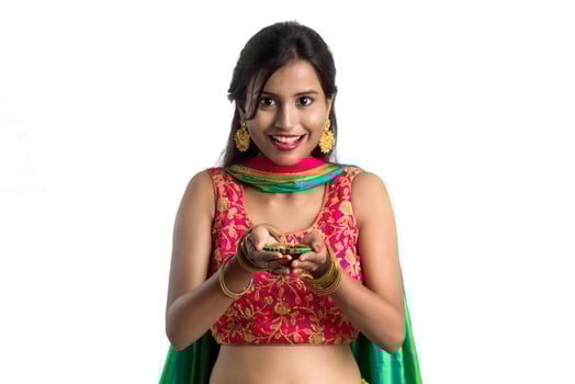 Portrait of a Indian Traditional Girl holding Diya, Girl Celebrating Diwali or Deepavali with holding oil lamp during festival of light on white background photo