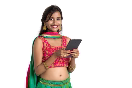 Young Indian traditional girl using a mobile phone or smartphone isolated on a white background photo