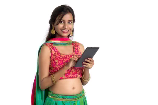 Young Indian traditional girl using a mobile phone or smartphone isolated on a white background photo